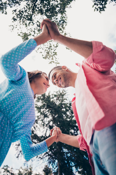 两名年轻情侣学生在森林边缘手牵手跳舞的特写照片图片下载