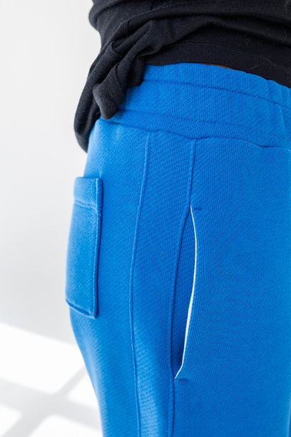 黑色卫衣和蓝色裤子的特写，背景为白色。工作室摄影。竖版照片。图片下载