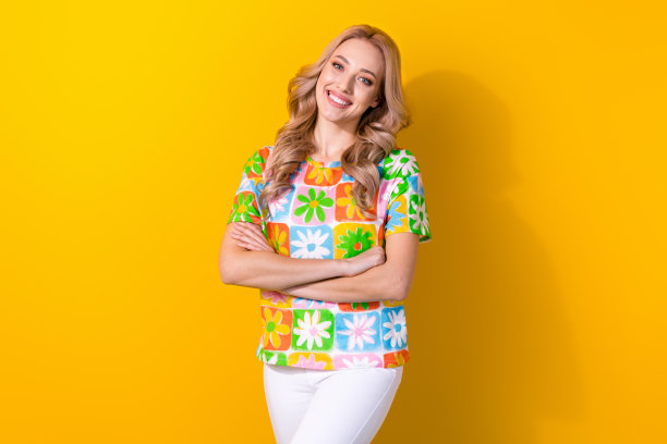 可爱的女士照片肖像，华丽的卷发造型，双臂交叉，积极向上的人，背景为黄色。图片下载