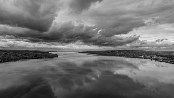 黑白全景航拍照片，拍摄于纽约兰辛的凯尤加湖，靠近伊萨卡，拍摄于阴云密布的早晨。云彩映照在平静的水面上。图片下载