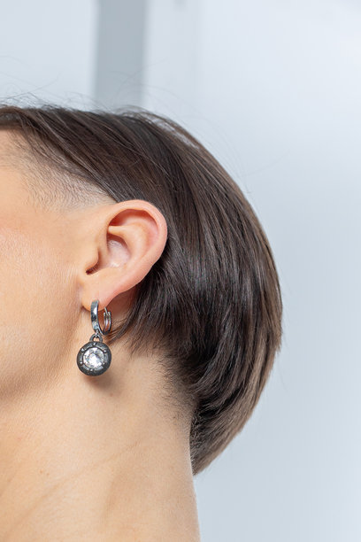 女孩耳朵上的耳环特写。美丽的珠宝女性饰品。工作室摄影。竖版照片。图片下载