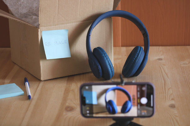 在线卖家使用智能手机拍摄耳机照片以便转售图片下载