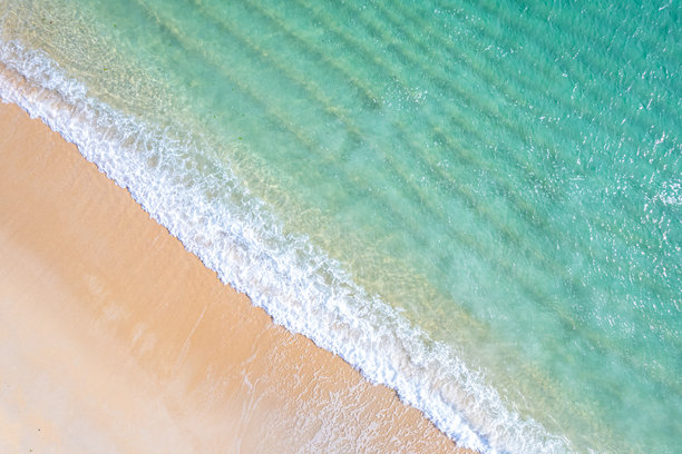海滩波浪与沙滩相遇的碧蓝水面，俯视视角的航拍照片图片下载