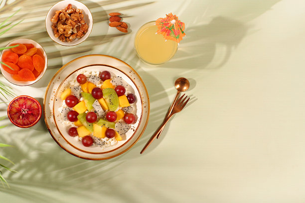 健康的轻早餐，包含食材：水果沙拉，搭配软质谷物奶酪、酸奶、火龙果、猕猴桃、芒果、橙子、坚果、葡萄和果汁。图片下载