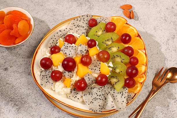 水果沙拉，配有软质谷物奶酪、酸奶、火龙果、猕猴桃、芒果、橙子、坚果、葡萄和果汁，健康轻盈的早餐，适合健康饮食生活方式的广告。图片下载
