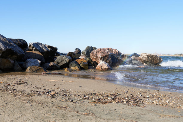 湖岸边的大石头和彩虹。美丽的照片壁纸。图片下载