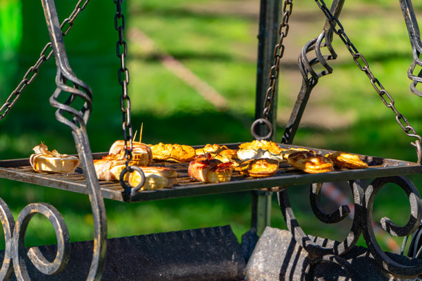 传统的波兰熏制奶酪，称为oscypek，在户外烤制。这些来自塔特拉山脉的地方美食通常与蔓越莓酱或其他配料一起温热食用。照片展示了一个乡村风格的金属烤架。图片下载