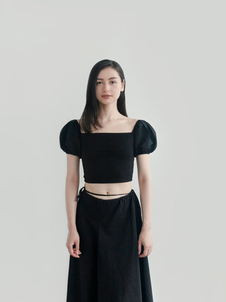 穿着时尚浪漫服装的美丽女性，韩国风格美学，黑色上衣和裙子，简约而美丽，时尚品牌的造型拍摄，年轻模特在明亮背景下摆姿势，时尚潮流的服装。图片下载