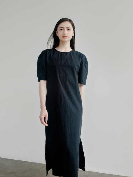 穿着时尚简约服装的美丽女性，韩国风格美学，黑色连衣裙显得既漂亮又自信，时尚品牌的造型拍摄，年轻模特在明亮背景下摆姿势，时尚潮流的服装。图片下载