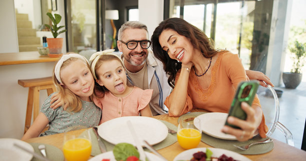 家庭在餐桌上一起享用午餐的搞笑自拍，记录下美好的回忆和亲密的联系。摄影、食物以及父母与女儿们的健康餐点，适合用作个人资料照片。图片下载