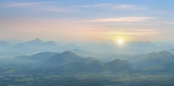 这张令人惊叹的山脉风景库存照片展现了大自然的壮丽美景。随着太阳落下，温暖的金色光辉洒在雄伟的山峰上，形成了一个迷人的场景。图片下载