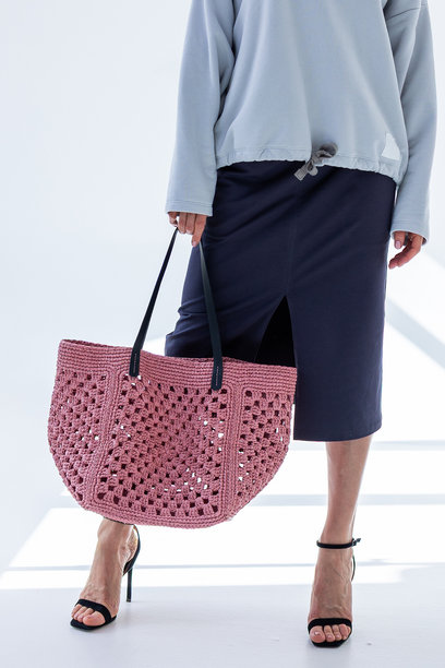 女性手持时尚的粉色编织包。时尚与奢华配饰。底部视角。竖版照片。图片下载