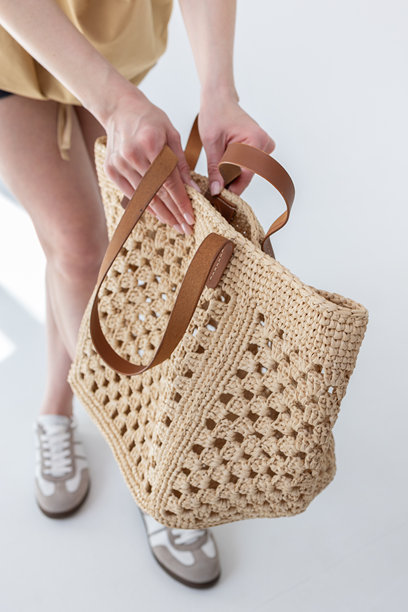 女性手持时尚编织包。时尚与奢华配饰。竖版照片。图片下载