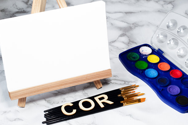 水彩画布、深色画笔和用葡萄牙语书写的“COLOR”木字，聚焦于儿童艺术的多元文化创意场景图片下载