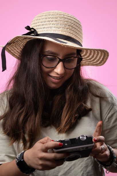 女人在检查复古相机上的照片图片下载