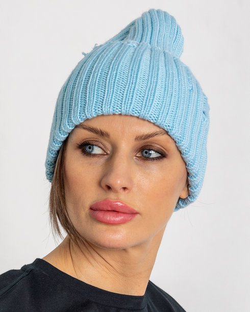 穿着蓝色帽子的美丽女性肖像。穿着温暖衣物的漂亮女孩在灰色背景下。工作室摄影。竖版照片。图片下载