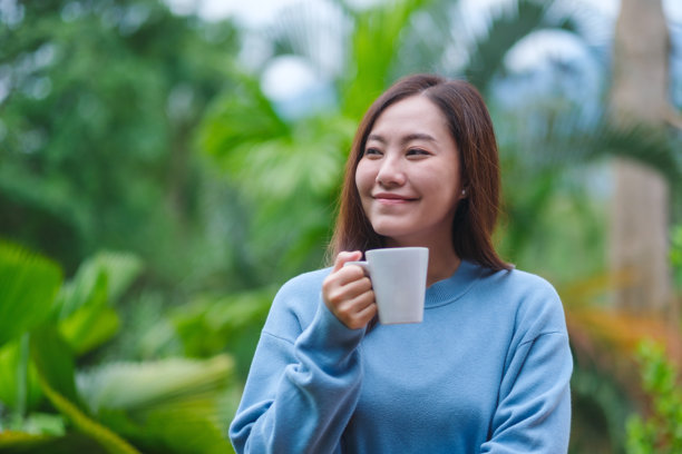 一位女性在花园中喝咖啡放松的肖像照片图片下载