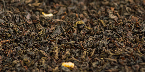 以佛手柑为背景的黑茶特写照片。茶叶的网页尺寸照片。图片下载