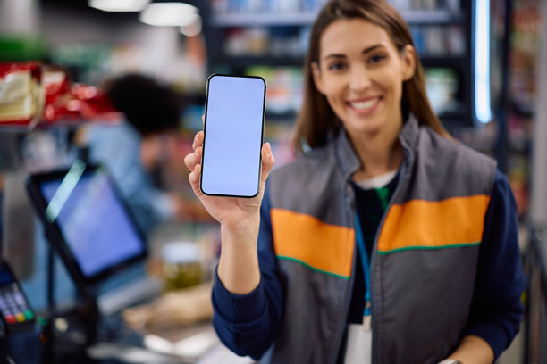 超市收银员手持空白屏幕的手机特写。图片下载