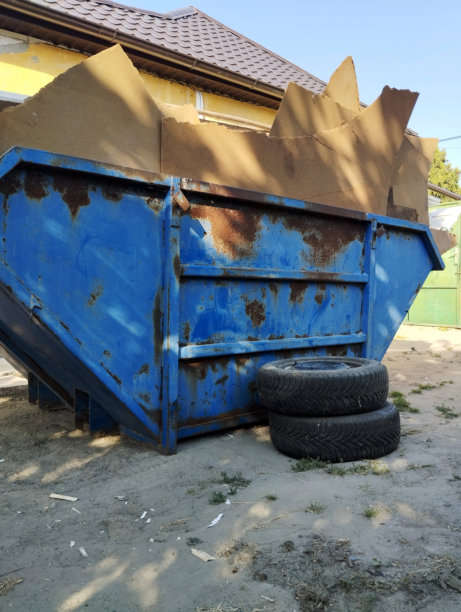 蓝色垃圾箱内装有旧木材、胶合板和建筑废料的照片图片下载