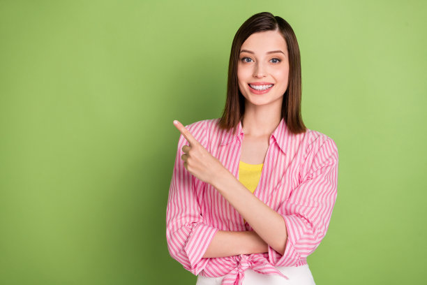 梦幻般的积极美丽女孩在绿色背景上宣传产品推荐的照片图片下载