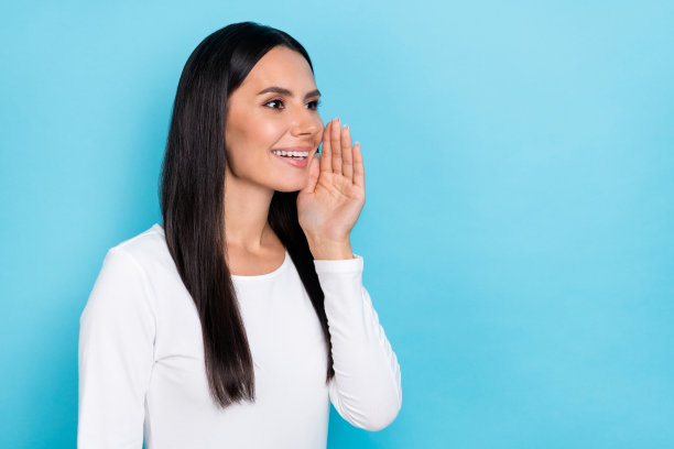 年轻可爱的女性侧面照片，望向空旷的空间，适合广告宣传，背景为蓝色。图片下载
