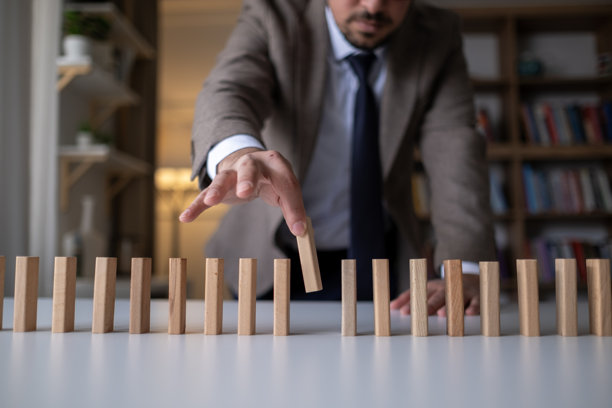 商人手中放置或拉动木质多米诺骨牌，带有品牌文本。以及市场营销、广告、标志、设计、战略、身份、信任和价值观。产品开发概念图片下载