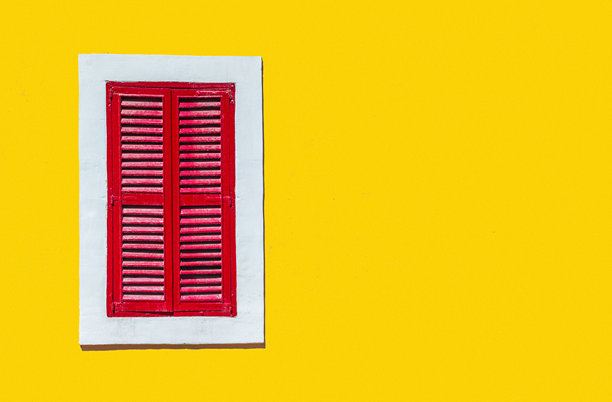 意大利威尼斯穆拉诺岛的黄色墙壁与白色框架红色窗户的极简风格照片图片下载