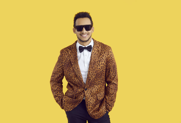 一位自信的年轻黑人男士穿着豹纹夹克、蝴蝶结和太阳镜的工作室拍摄照片图片下载