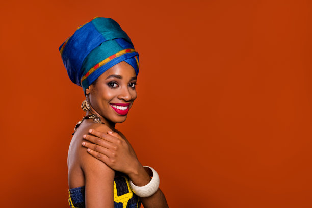 穿着传统帽子的光滑皮肤甜美女性照片，背景为红色，空白空间。图片下载