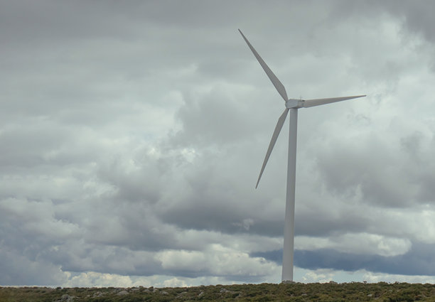山间磨坊的照片，背景是戏剧性的云层天空。可再生能源图片下载