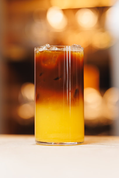 背景模糊的无酒精鸡尾酒。温暖色调的照片，多层鸡尾酒，盛在美丽杯子里的饮品。图片下载