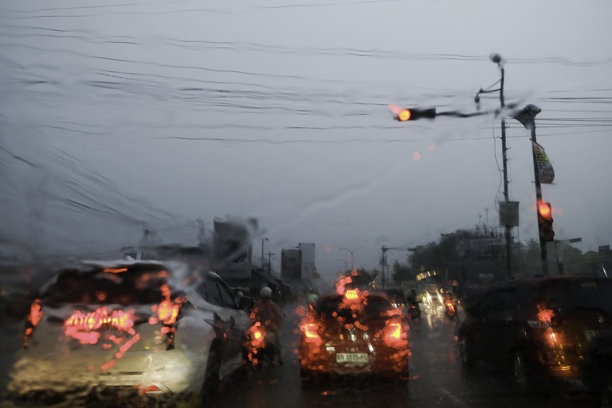 在佩卡巴鲁，雨中模糊的车辆灯光照片。车内视角的雨景。图片下载