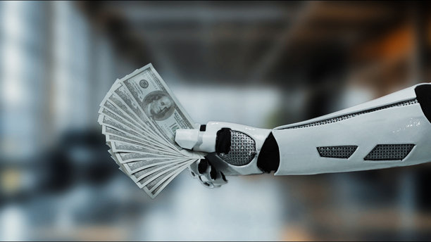 机器人手在现代办公室环境中握着现金，象征着自动化、技术和未来金融概念，适用于库存照片收藏。图片下载