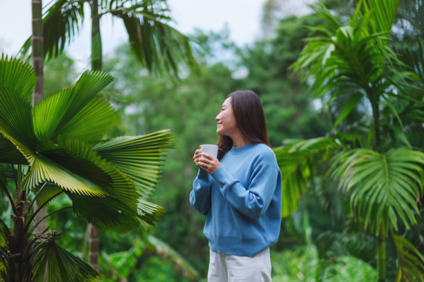 一位女性在花园中喝咖啡放松的肖像照片图片下载