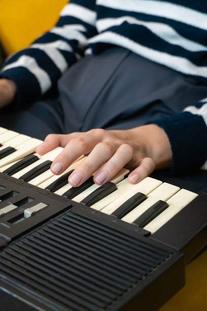 手指在复古合成器的键盘上舞动，创造出复杂的旋律和丰富的电子音效，展现出一位专注音乐家的技巧与热情。竖版照片图片下载