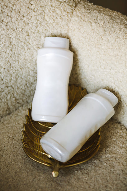 米色椅子上的白色化妆品洗发水瓶模型。特写照片图片下载