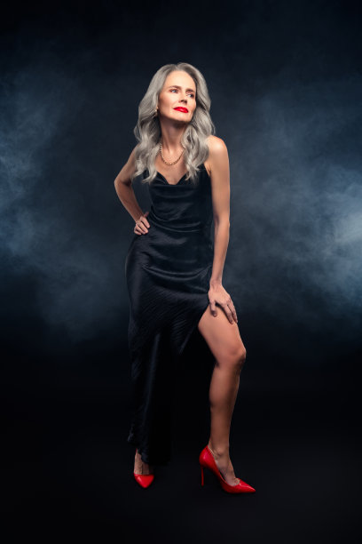 优雅晚礼服的迷人成熟的女性，展现华丽风格和优雅姿态，竖版照片图片下载