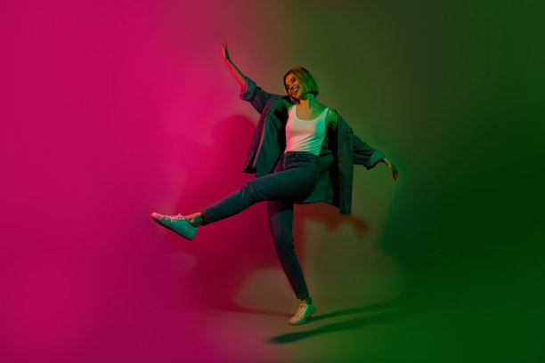 充满活力的积极快乐女士在未来派夜总会中跳舞的全身照片，背景是多彩的网络霓虹色。图片下载