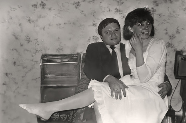 复古的新郎新娘肖像。新娘坐在新郎的腿上。1993年的复古照片。图片下载