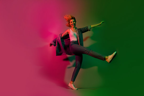 充满活力的女士在渐变色彩霓虹背景下玩虚拟现实舞蹈模拟的全身照片图片下载