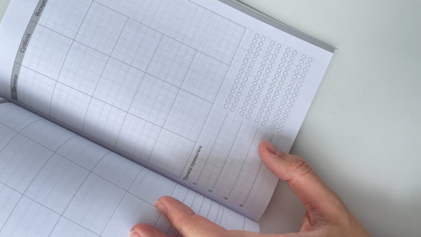 手部特写翻阅月度计划本，适合展示组织、规划和生产力。这张高质量的图片非常适合用于教育、商业和时间管理项目。图片下载