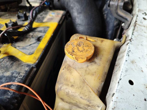 汽车引擎盖上安装的玻璃喷雾器水箱和电池图片下载