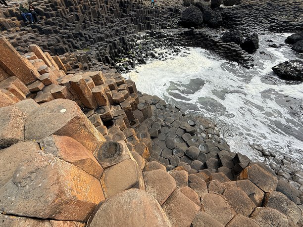 巨人之路，位于北爱尔兰安特里姆海岸，是联合国教科文组织世界遗产，拥有40,000根相互交错的玄武岩柱，形成于火山活动。其六边形石柱和海岸美景令人惊叹，非常适合自然类库存图片。图片下载