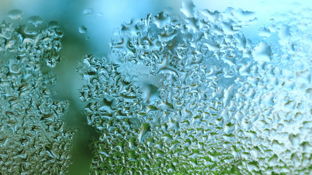 玻璃上的水滴。滴落的雨滴纹理背景。雾气弥漫的窗户特写，水滴顺着窗户流下。空气湿度增加。雨天。蓝绿色调。高质量照片。图片下载