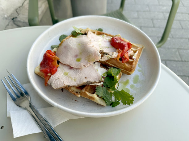 户外桌上的土豆华夫饼配火鸡腌肉、烤甜椒、奶油奶酪和香菜。健康早餐概念。手工拍摄的移动照片，选择性对焦，非人工智能。图片下载