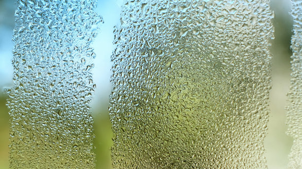 玻璃上的水滴。滴落的雨滴纹理背景。雾气弥漫的窗户特写，水滴顺着窗户流下。空气湿度增加。雨天。蓝绿色调。高质量照片。图片下载