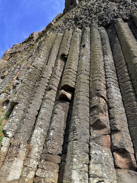 巨人之路，位于北爱尔兰安trim海岸，是联合国教科文组织世界遗产，拥有40,000根相互交错的玄武岩柱，形成于火山活动。其六边形石柱和海岸美景令人惊叹，非常适合自然类库存图片。图片下载