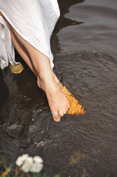 女人在当地炎热的夏季湖边坐着休息、放松或享受水疗的腿部特写照片图片下载