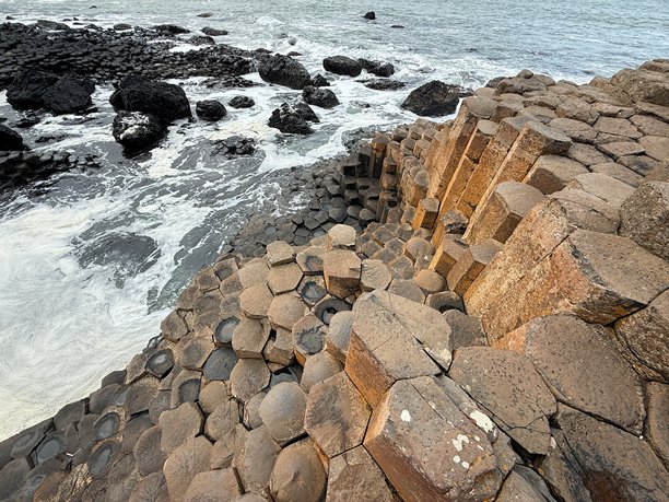 巨人之路，位于北爱尔兰安trim海岸，是联合国教科文组织世界遗产，拥有40,000根相互交错的玄武岩柱，形成于火山活动。其六边形石柱和海岸美景令人惊叹，非常适合自然类库存图片。图片下载